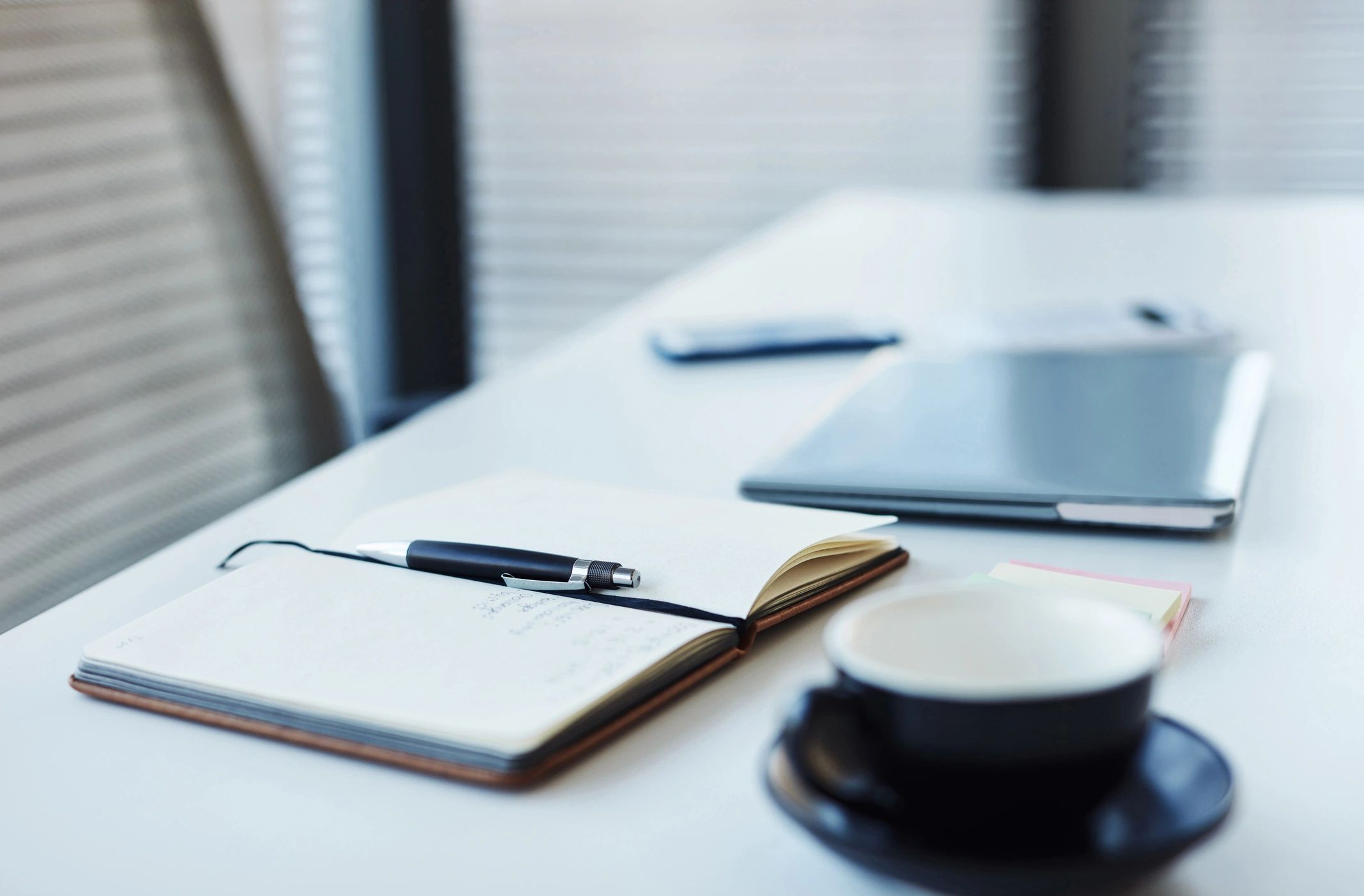Notebook and laptop on a desk, representing site notes and policies
