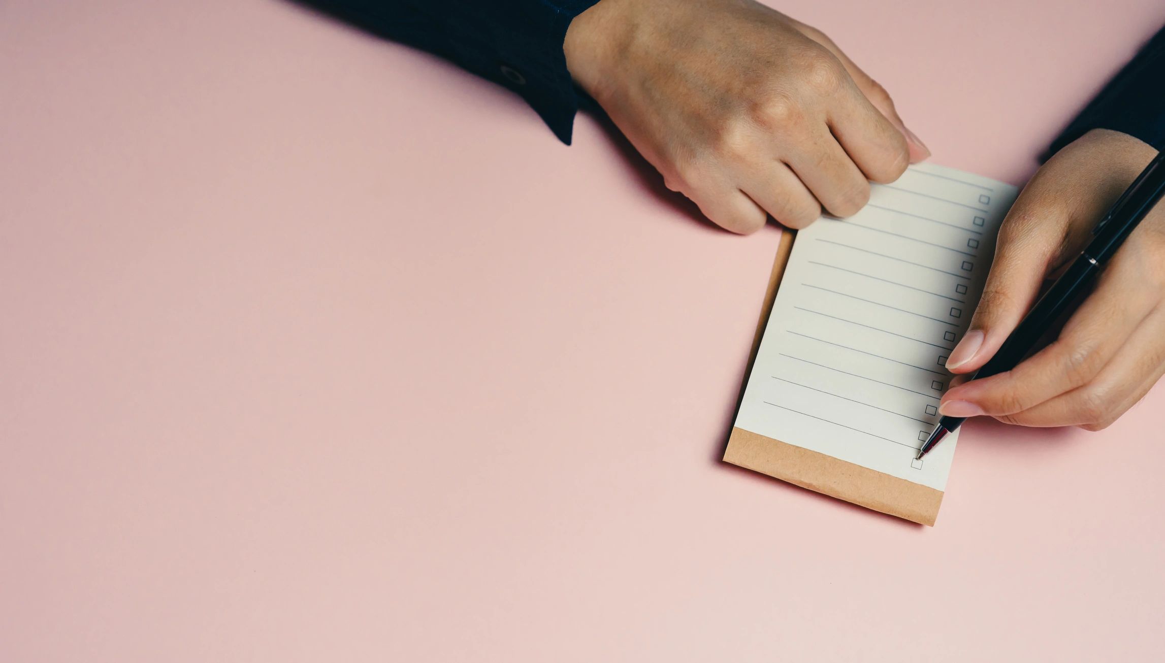 Close-up of hands writing in a notebook