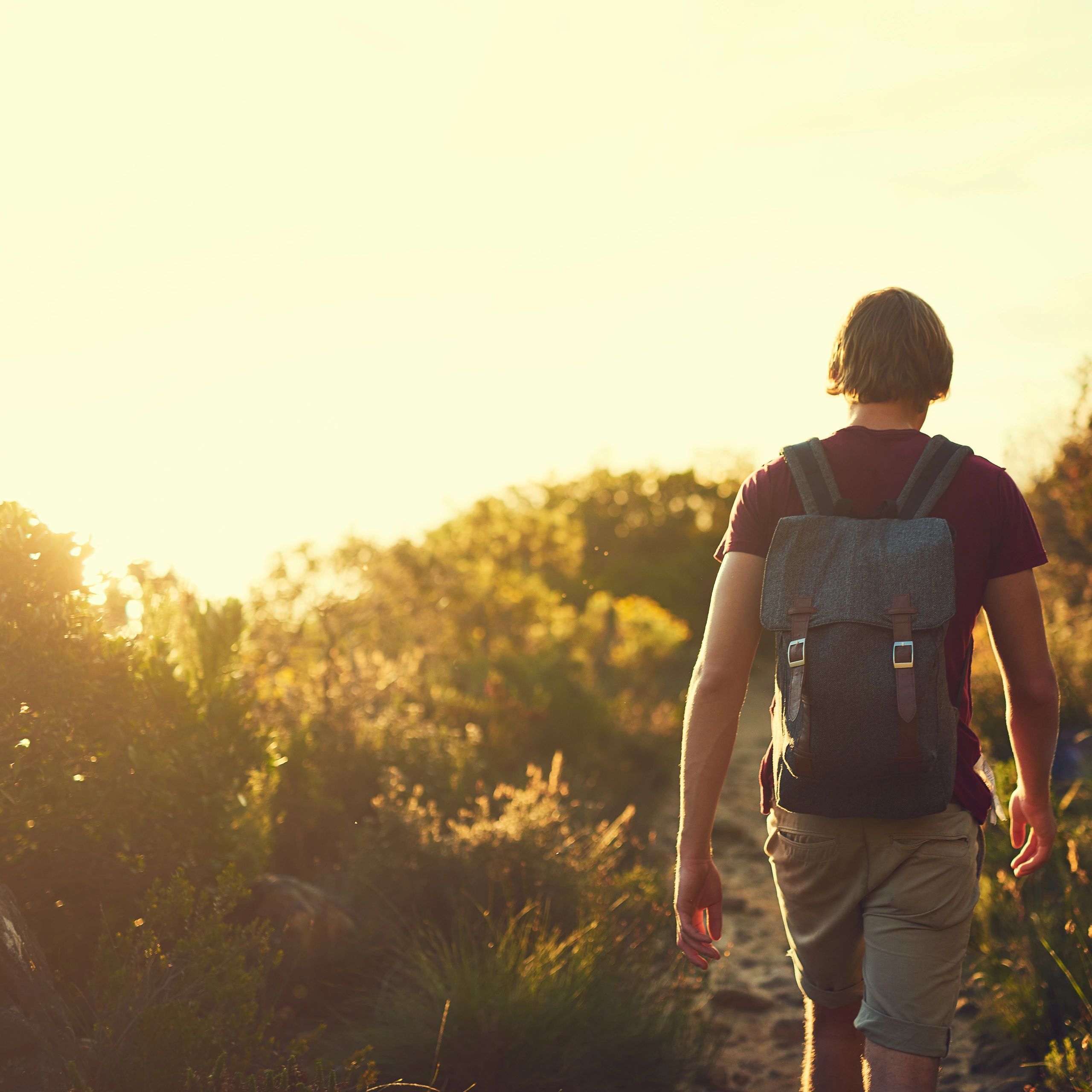Rearview shot of a man hiking a rugged mountain trail